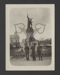 Drei Männer vor einem Kriegerdenkmal