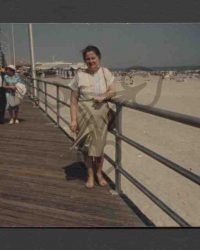 Unbekannte Frau auf einer hälzernen Strandpromenade